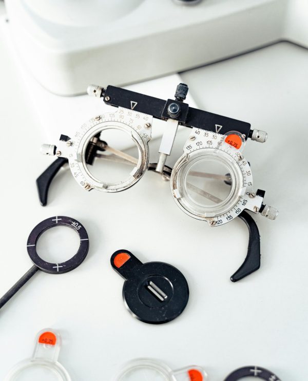 pexels-photo-6749736-6749736-1 Close-up of optometry trial frame and lenses on white surface.